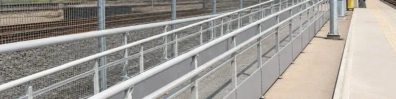 Modern UK railway infrastructure with train and GRP safety systems for transport projects.